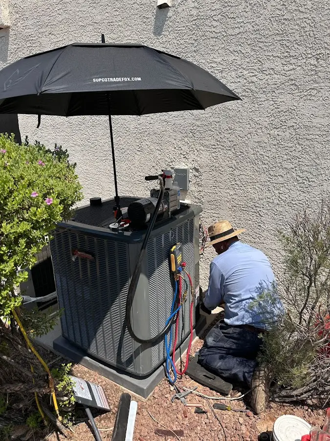HVAC technician performing outdoor AC maintenance in Gloucester